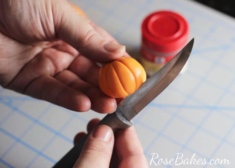 easy pumpkin cupcake topper neing shaped with knife