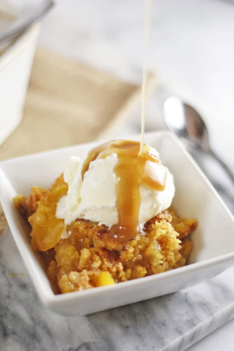 peach dump cake with vanilla ice cream and caramel sauce