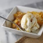 peach dump cake with ice cream and caramel