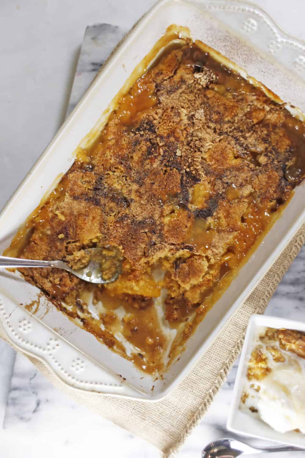 peach dump cake with some served into an individual serving bowl