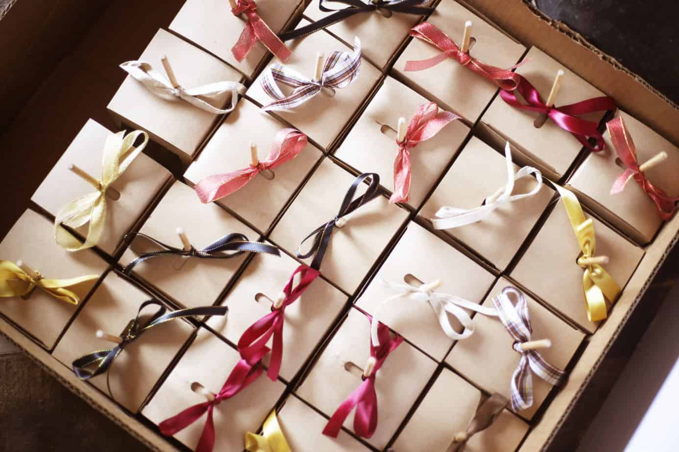 Boxed caramel apples with varying ribbons tied on the sticks on top