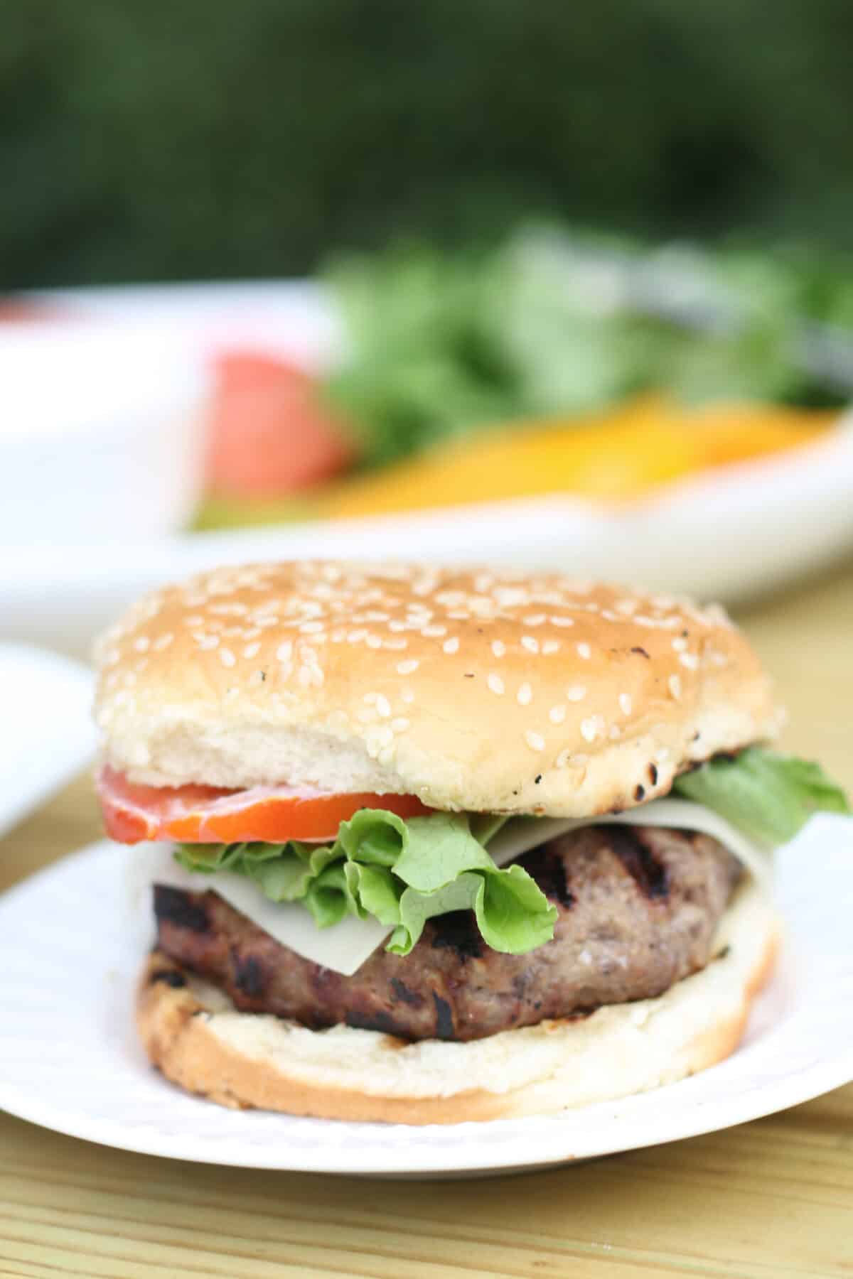 grilled burger dressed on a white plate