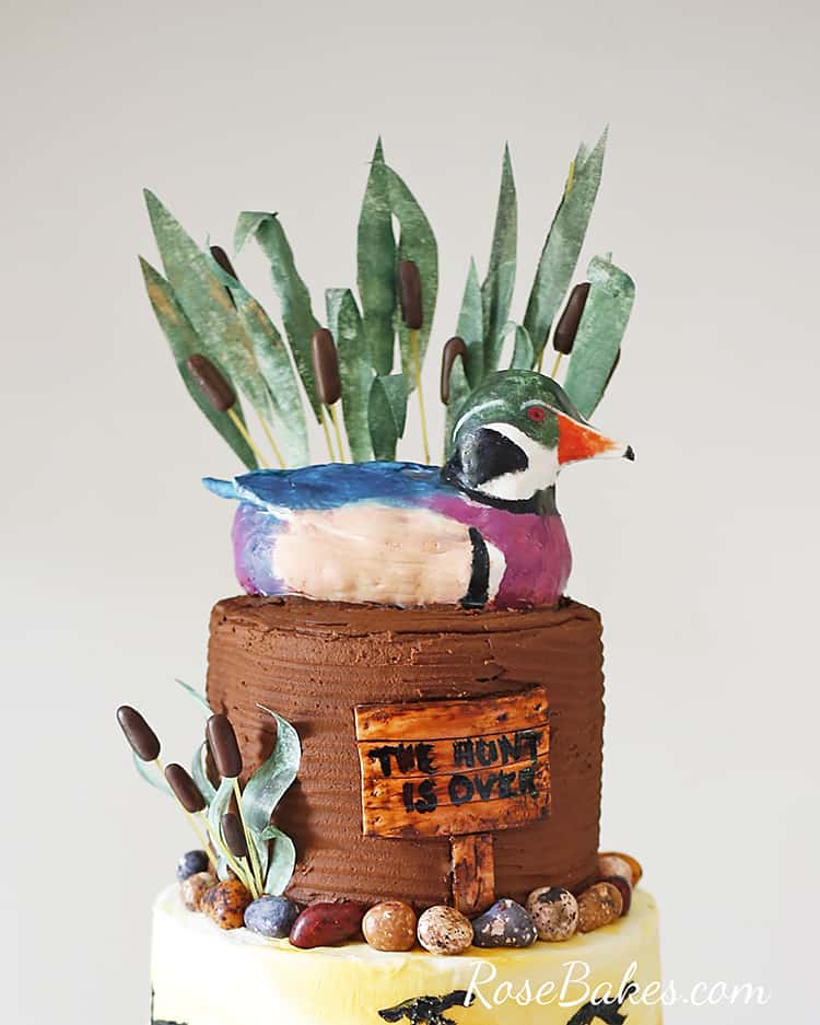 mallard duck cake topper with wafer paper grass and reeds behind it on duck hunting groom's cake