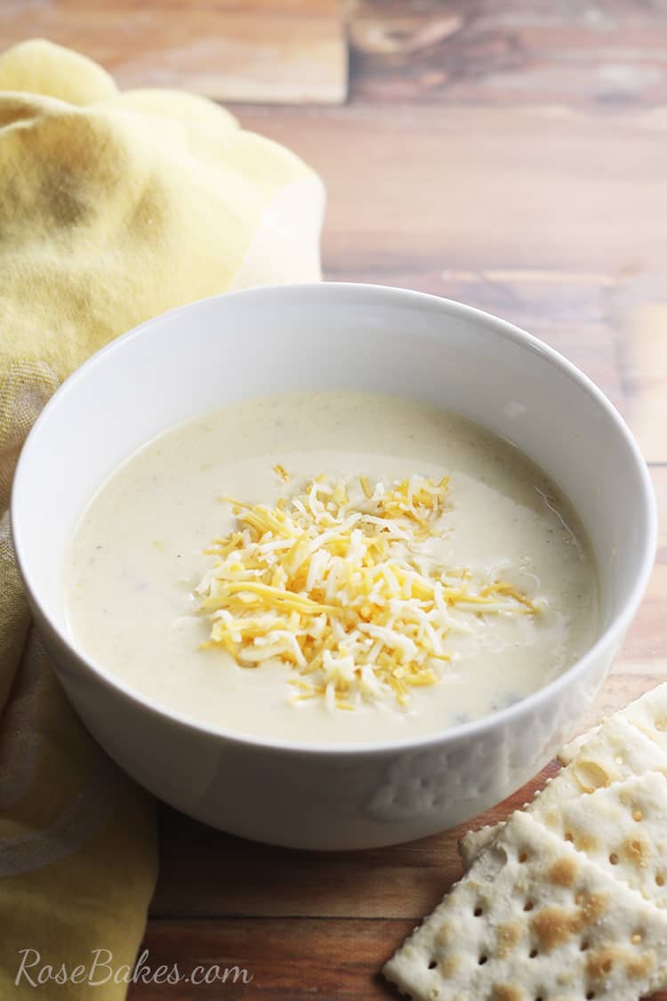 bowl of summer squash soup with cheese and saltine crackers