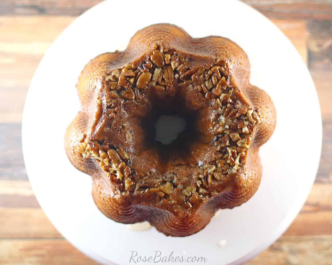 Whole Rum Cake from above with pecans on a white plate