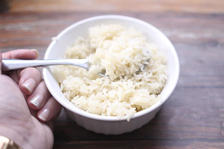 bowl of rice made in Instant Pot with spoon and hand