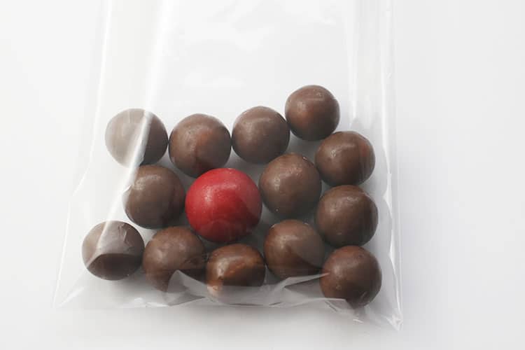 whoppers and red candy in treat bag for Reindeer Noses Treat Bags