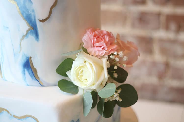 pink and white flowers on marbled fondant wedding cake