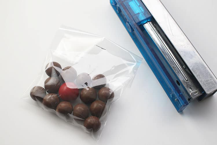 whoppers and red candy in stapled treat bag for Reindeer Noses Treat Bags