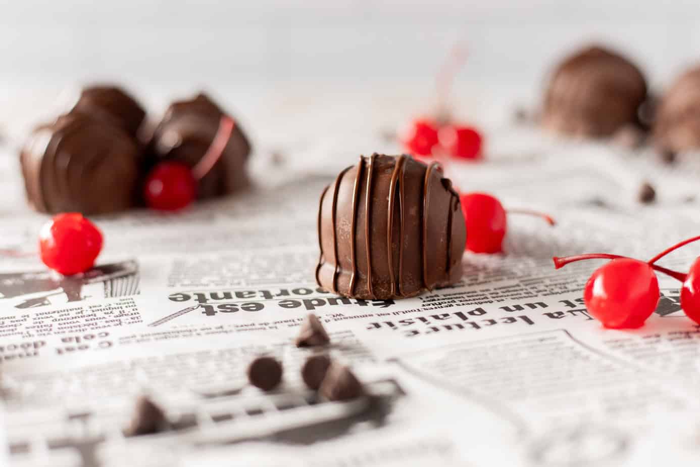 chocolate covered cherries on white print surface