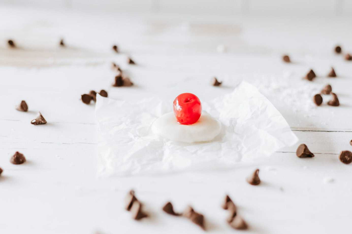 a maraschino cherry sitting on a flattened piece of fondant