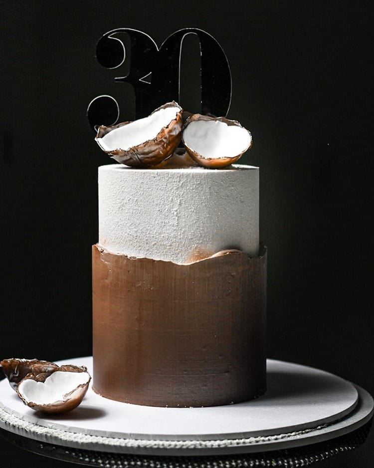 Tall single tier Coconut Fault Line Cake with Texture and a coconut shell on top and the number 30