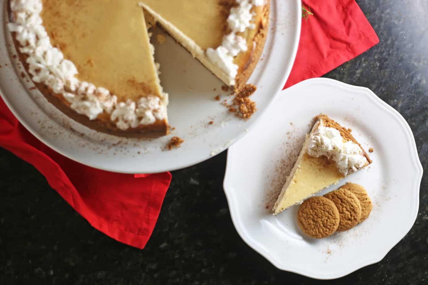 a slice of eggnog cheesecake on a white plate next to the whole cheesecake