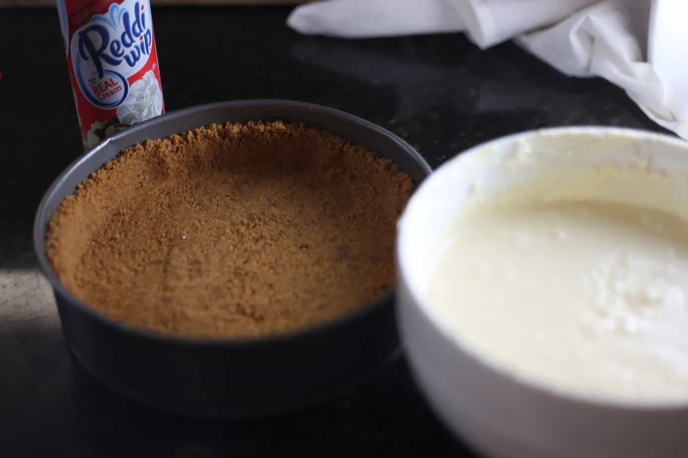 finished eggnog cheesecake filling in bowl next to finished crust