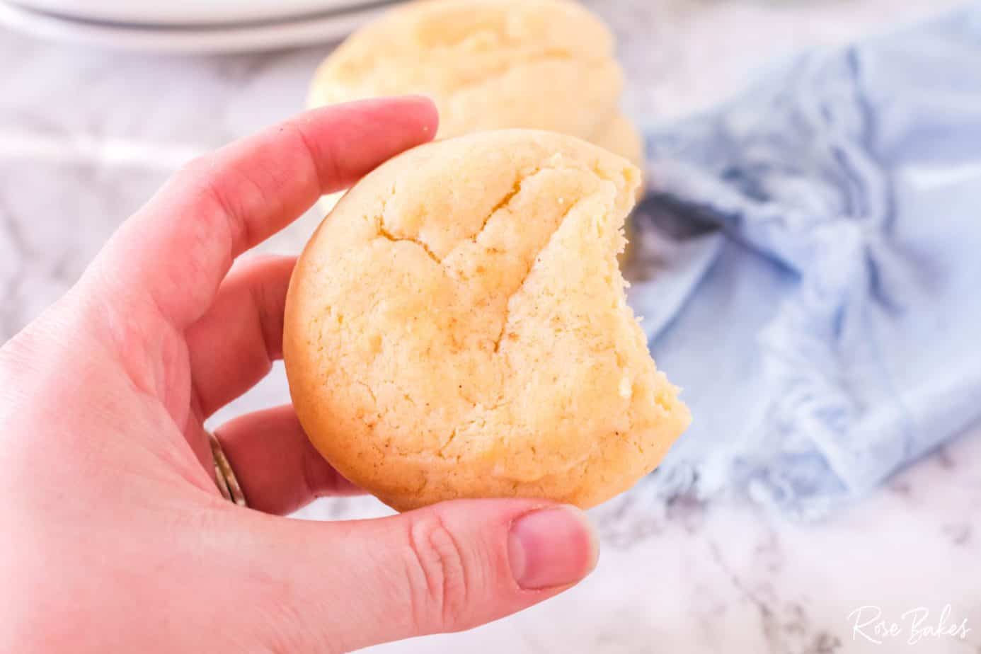 Eggnog Cookie being held with bite taken out.