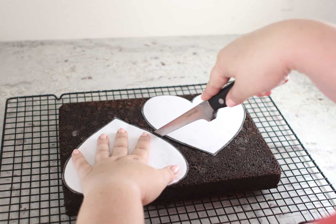 cutting hearts out of sheet cake using a heart template