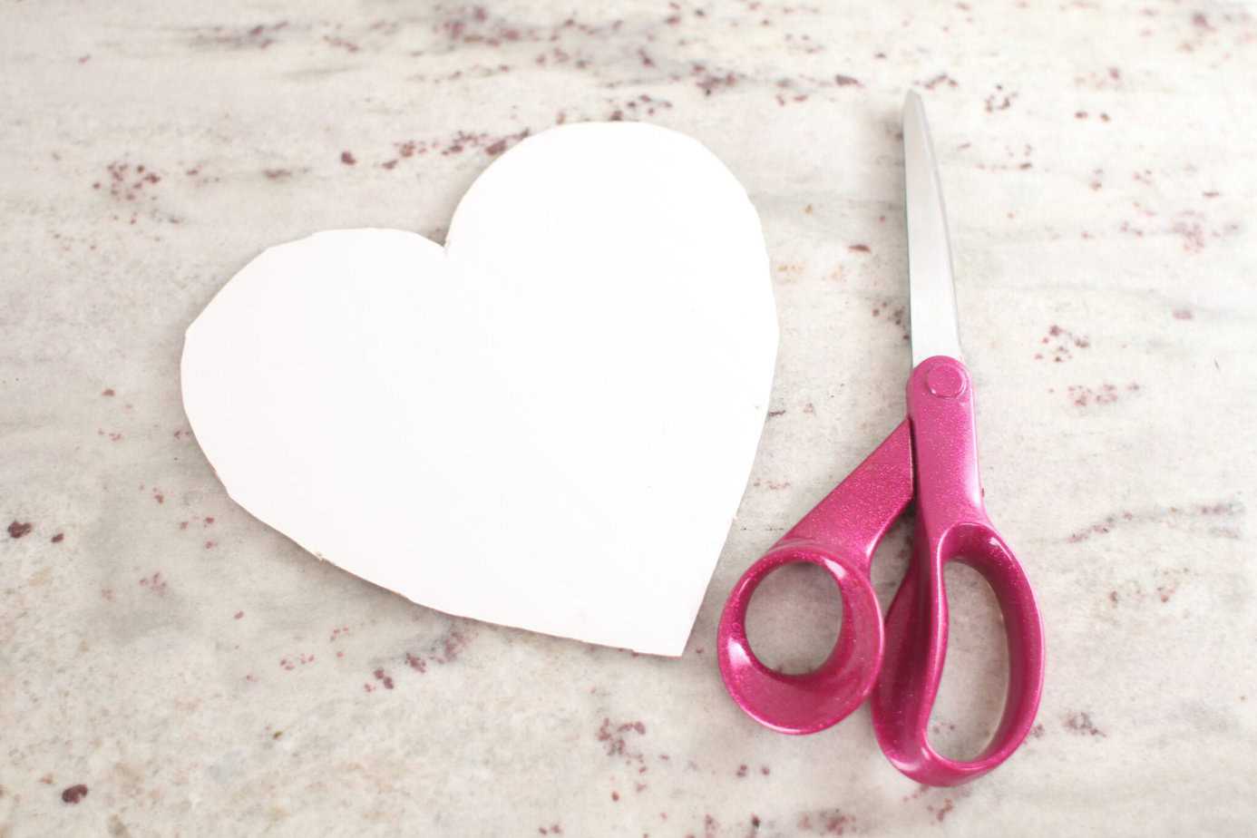 cutting heart out of template with pink scissors
