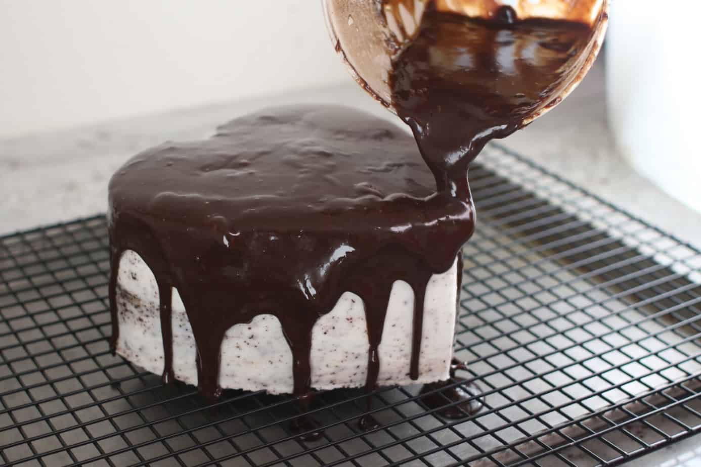 chocolate ganache being poured over a heart cake