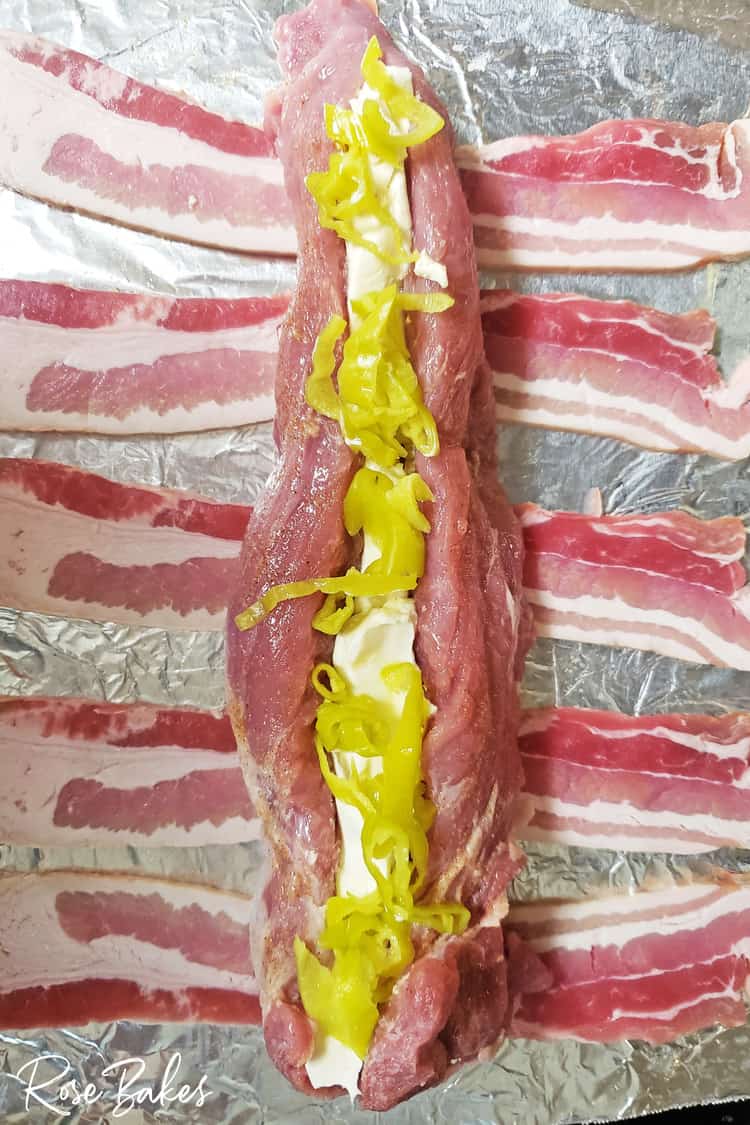 stuffed pork loin laying on strips of bacon