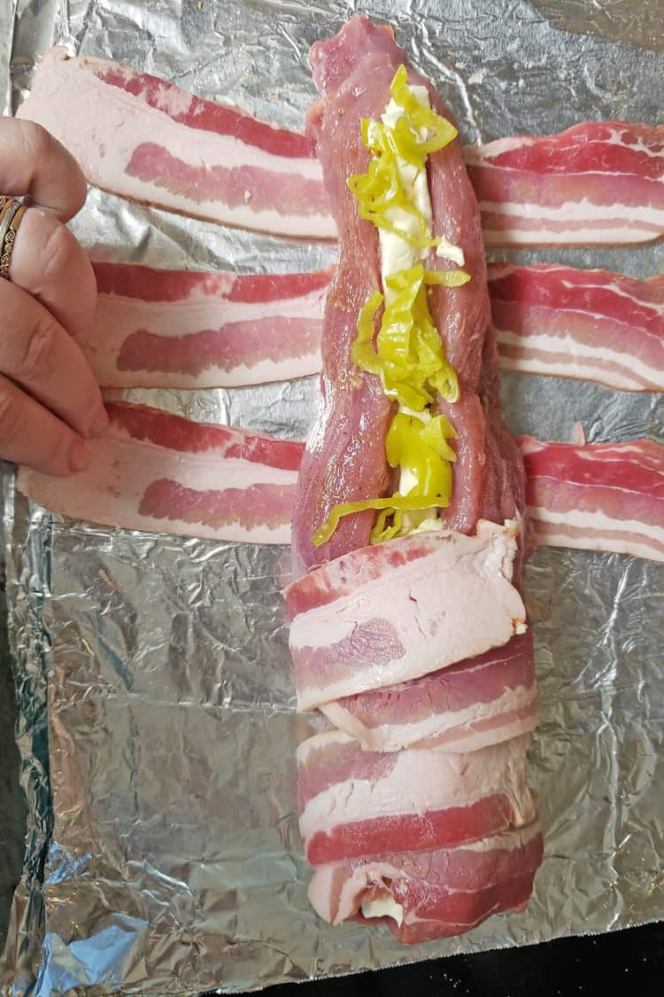 Porkloin wrapped in back and filled with pepperoncini and cream cheese half way wrapped