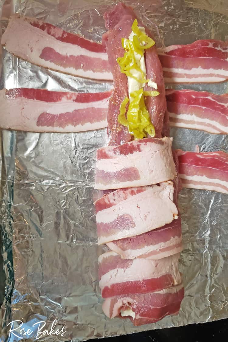 Porkloin wrapped in back and filled with pepperoncini and cream cheese three fourths wrapped