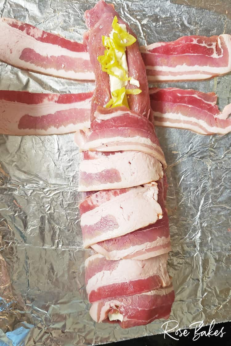 Porkloin wrapped in back and filled with pepperoncini and cream cheese Almost fully wrapped