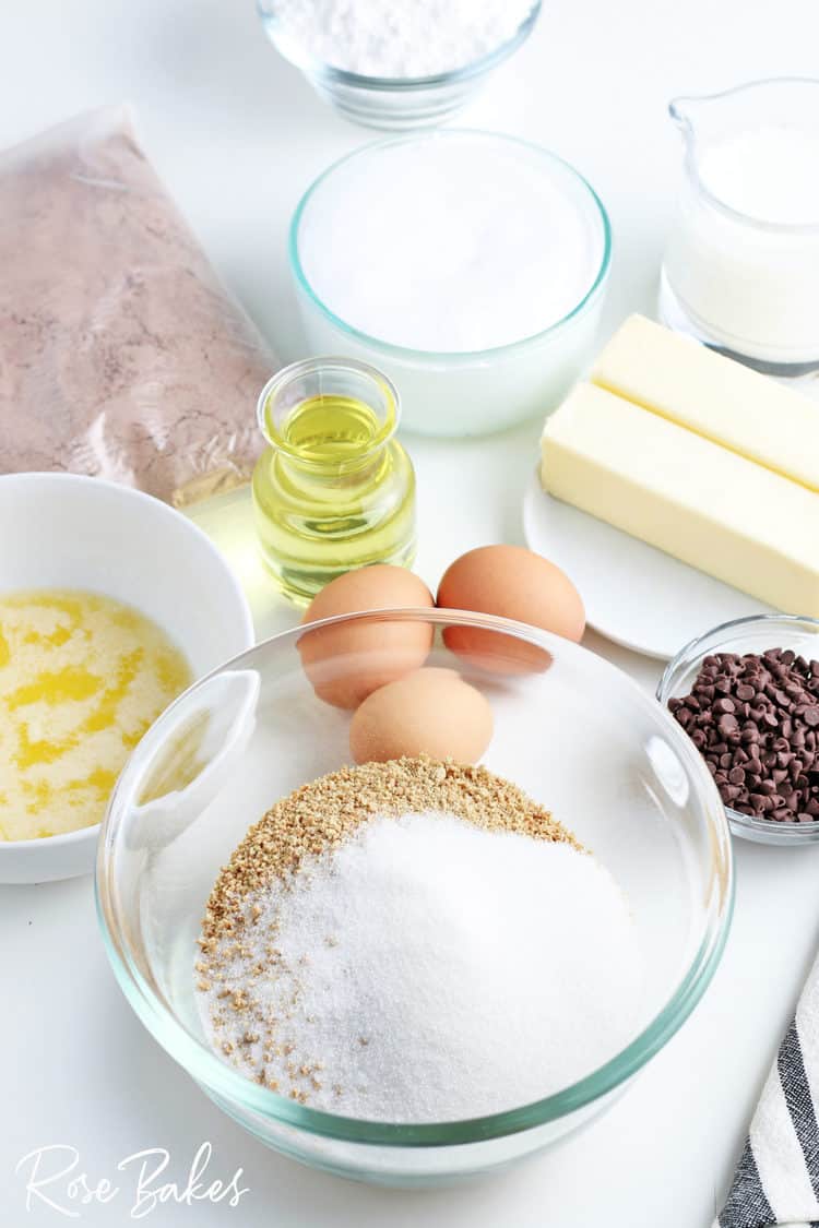 mixing bowl with graham cracker crumbs and sugar plus other ingredients in background