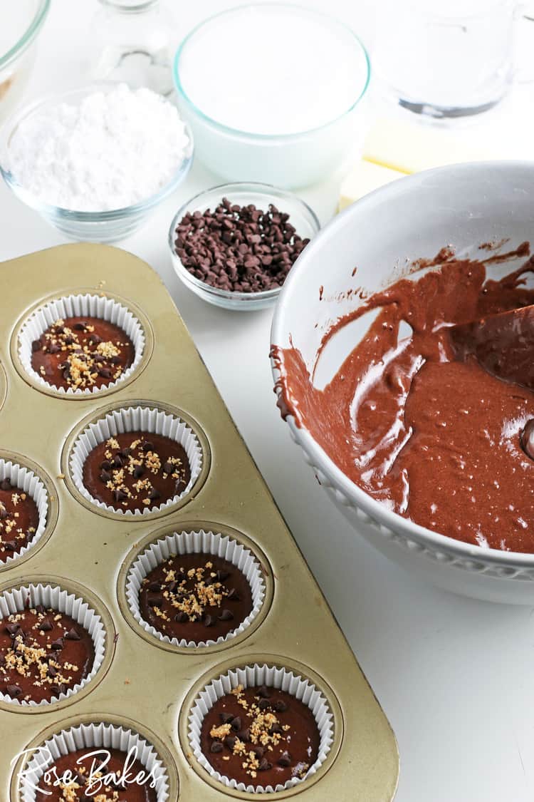mixing bowl with chocolate cake batter and batter scooped into cupcake pan for s'mores cupcakes