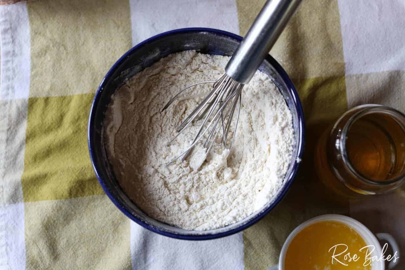 dry ingredients being whisked together in blue mixing bowl