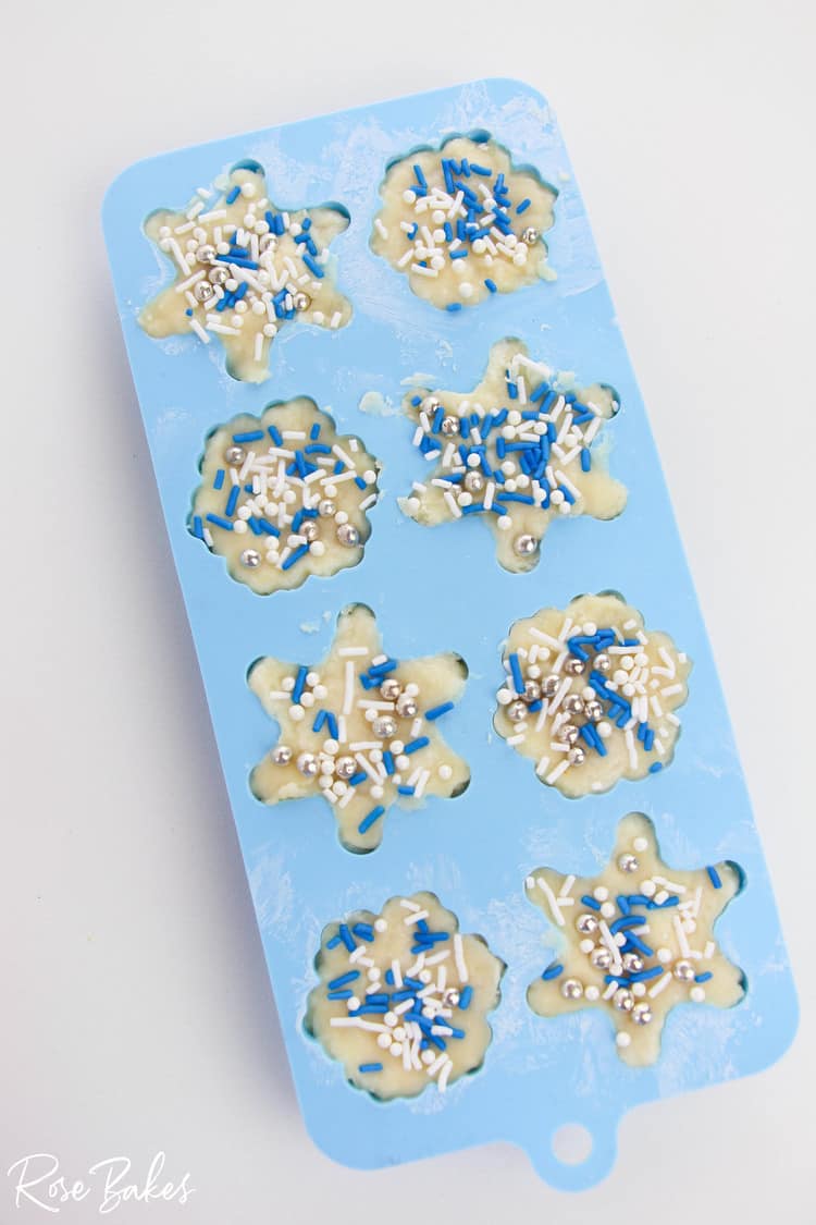 silicone snowflake molds filled with white chocolate fudge and sprinkles