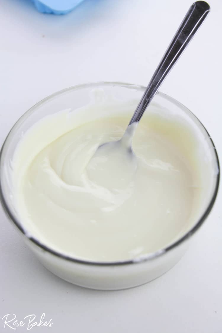 bowl of melted white chocolate with spoon.