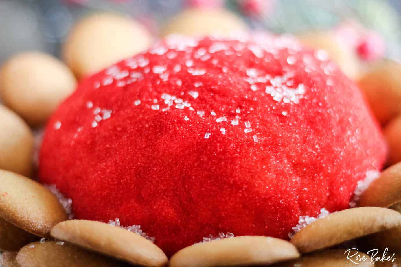 Cookie Dough Cheeseball rolled in red sparkling sugar with nilla wafers surrounding the ball.
