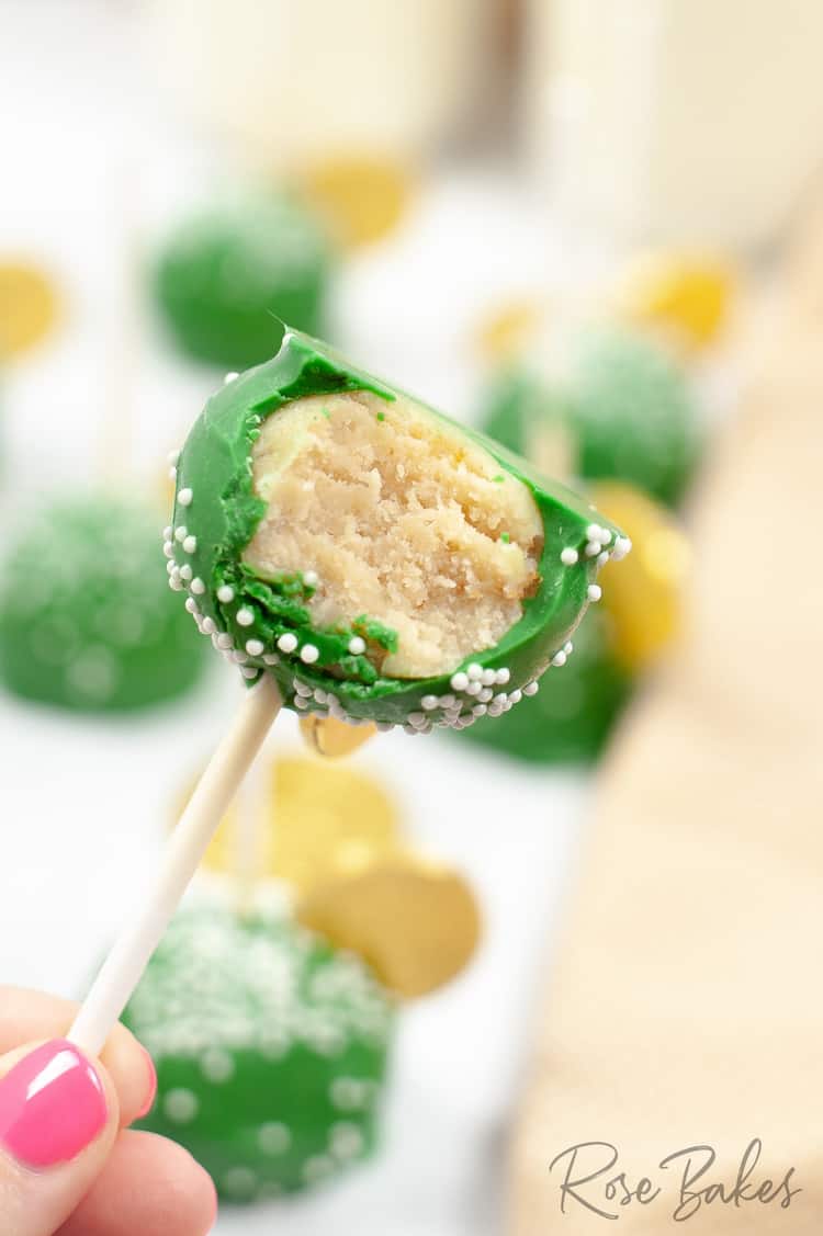 A cake pop with a bite taken out of it showing the inside.
