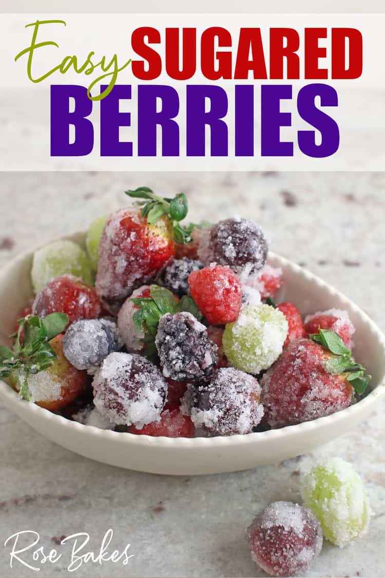 White bowl filled with sugared berries and grapes.