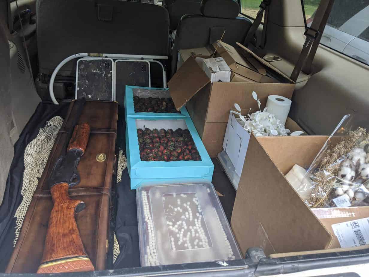 grooms cake and strawberries and other wedding food items in vehicle for transport