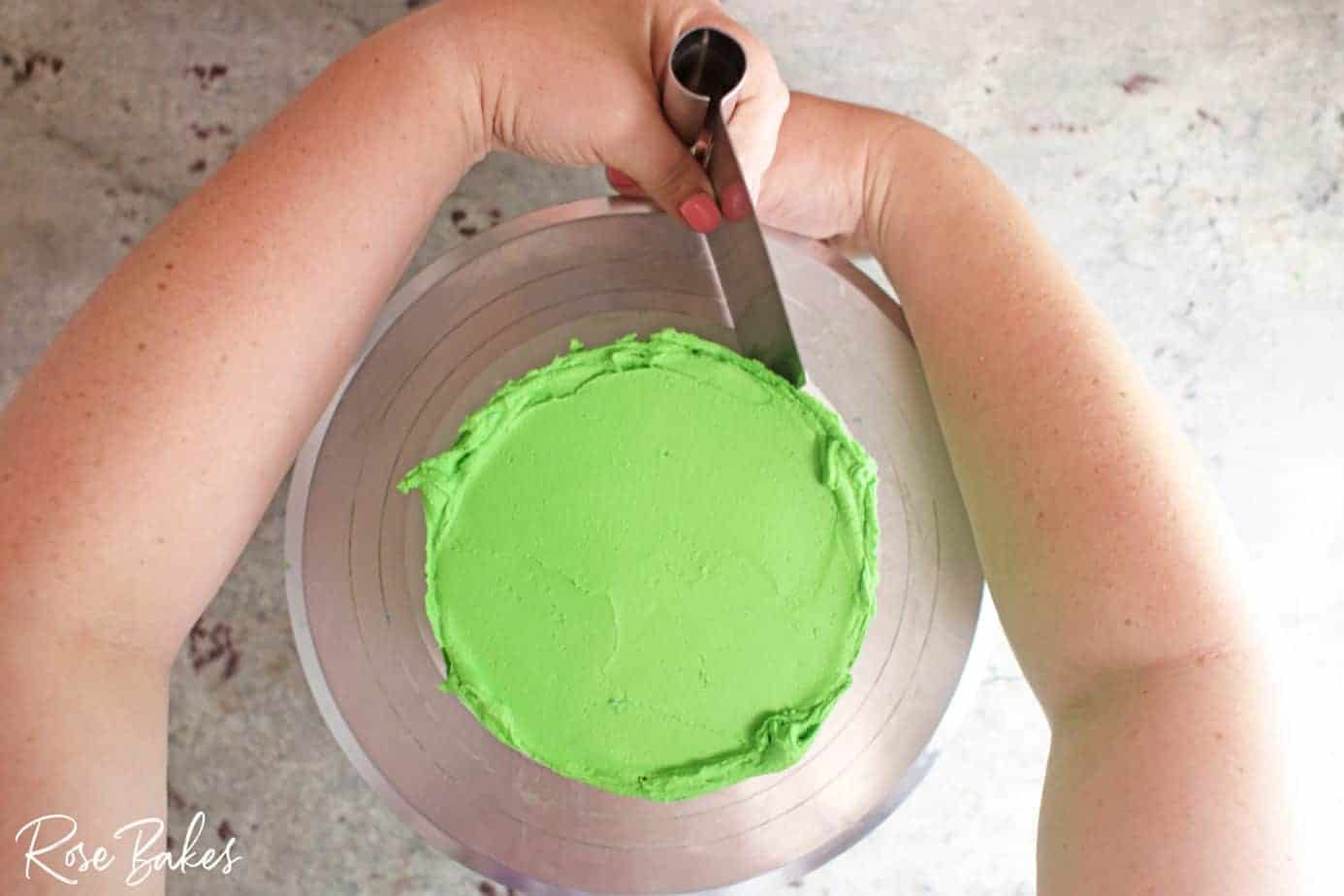 green icing being added to bottom tier on turntable 