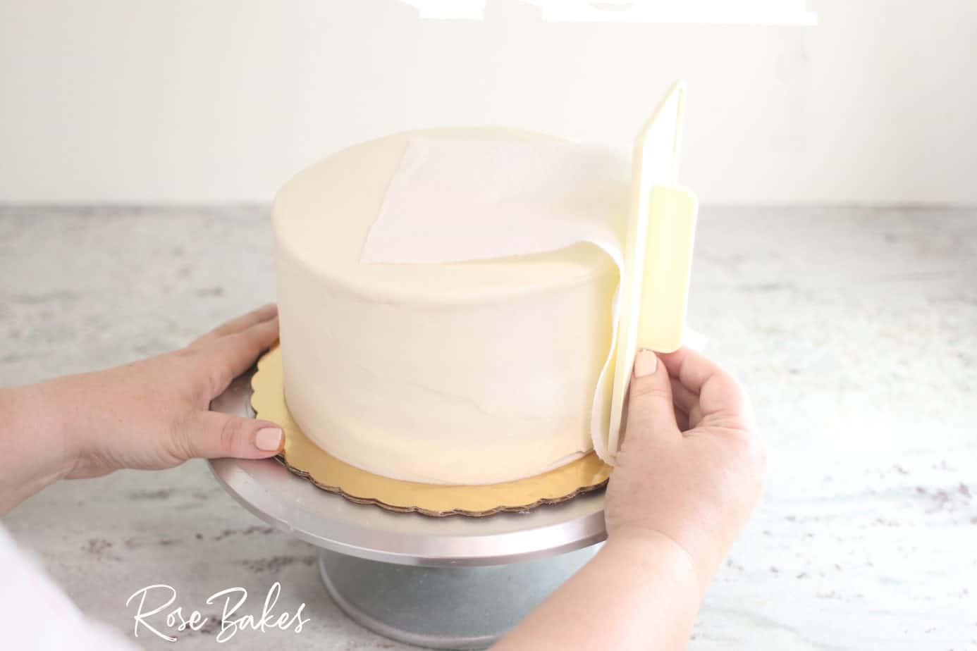 viva towel being used to smooth sides of buttercream icing cake 