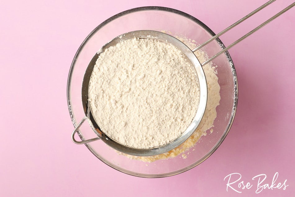 Flour and baking powder being sifted into the bowl.