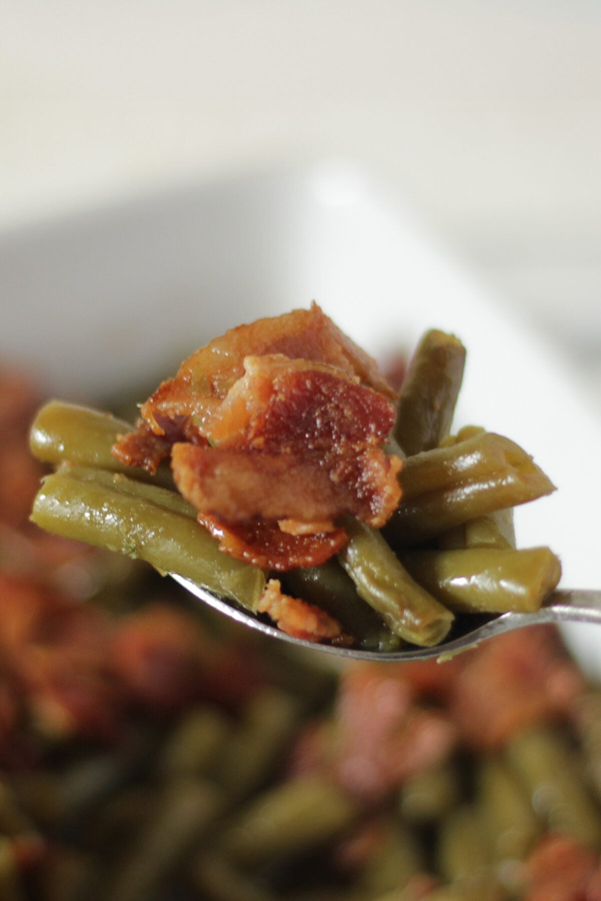 a bite of green beans with bacon and brown sugar