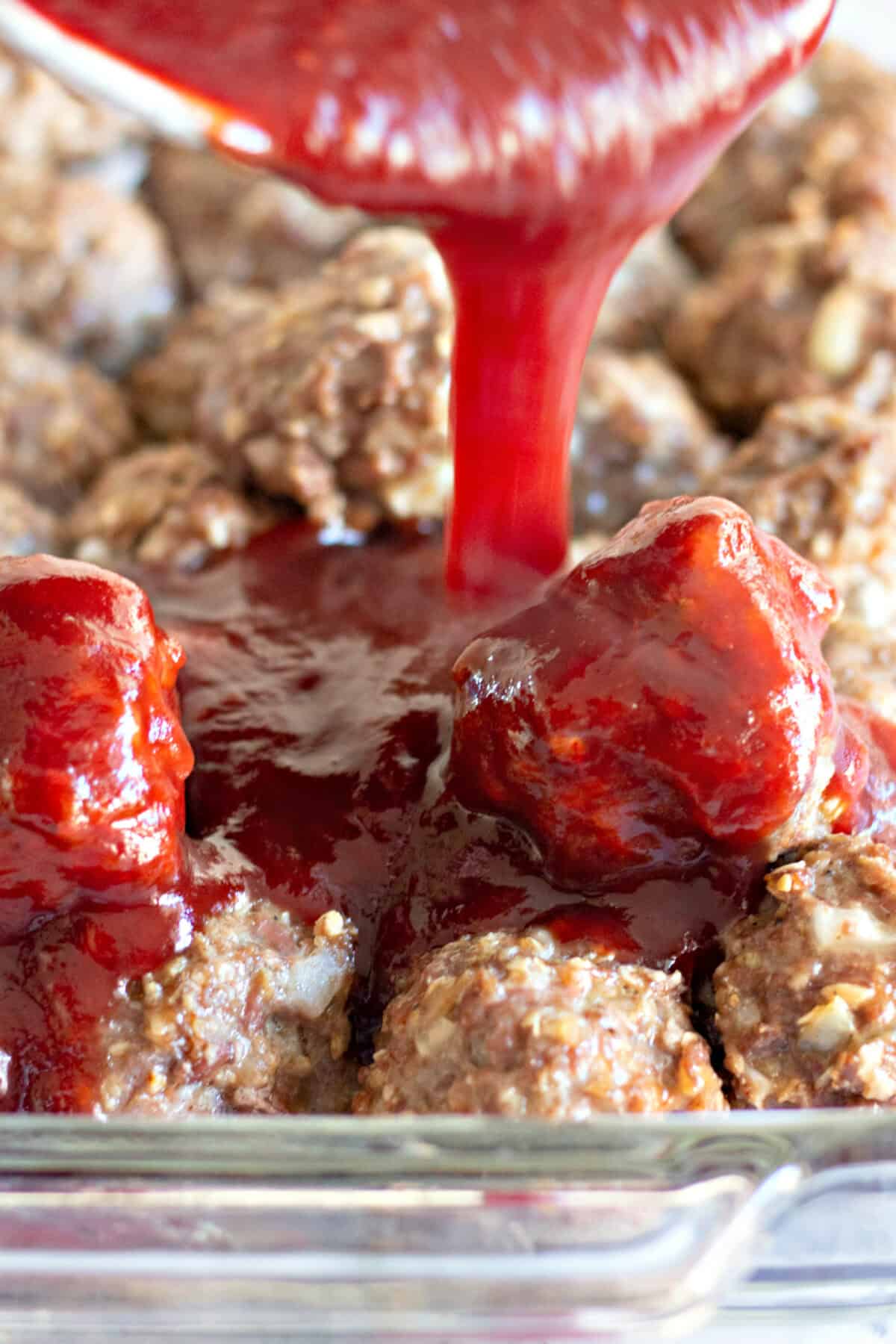 sauce being poured over meatballs