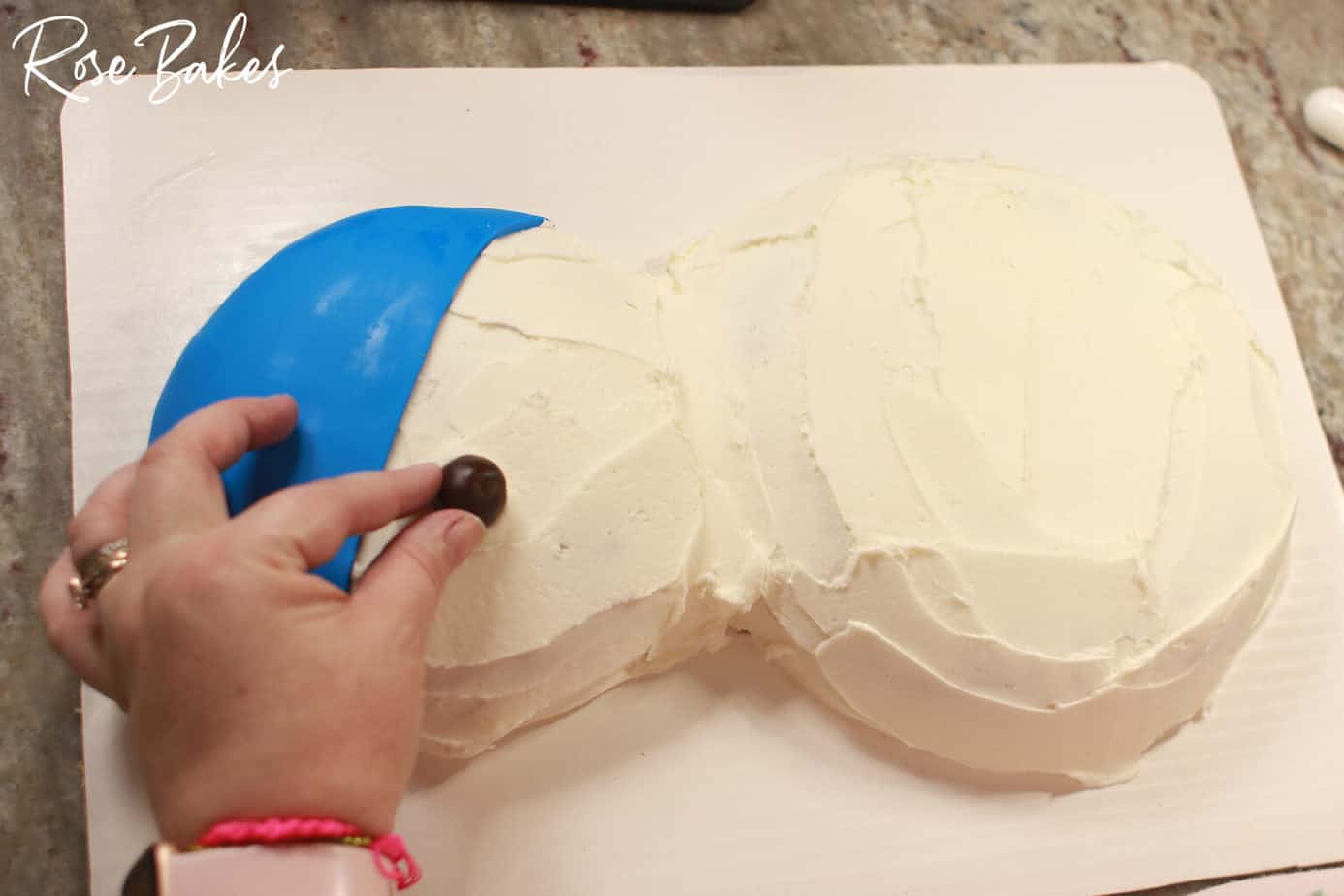 brown fondant being placed on cake for eyes