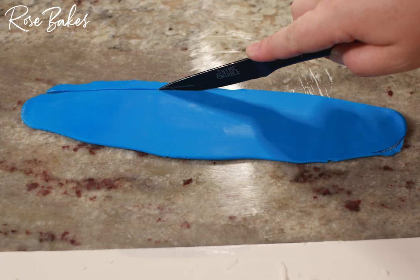 more blue fondant being cut