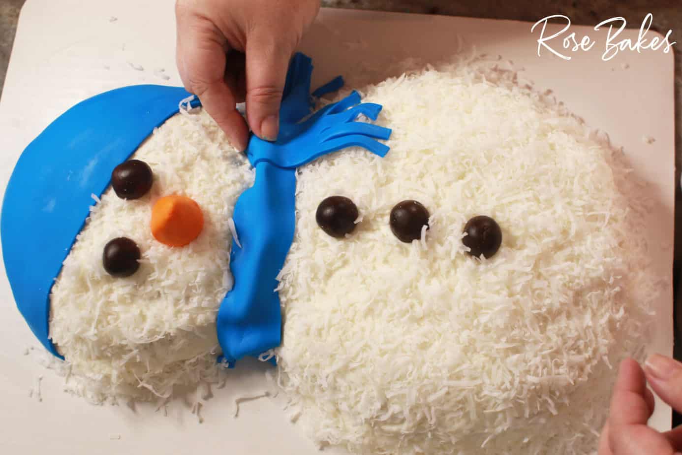 finishing touches of scarf on honey coconut gluten free cake