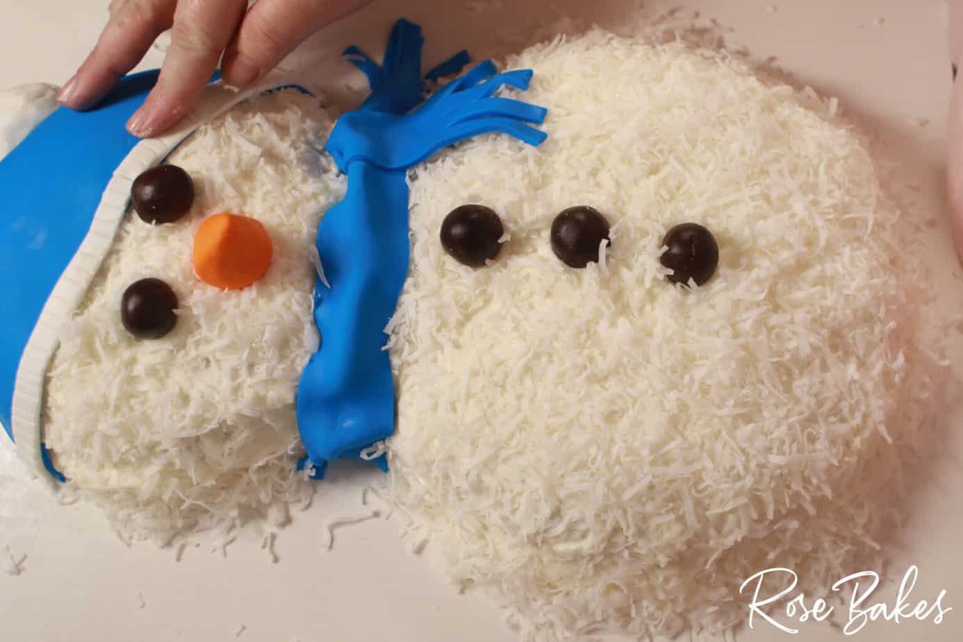 white fondant being put on honey coconut gluten free snowmans cap
