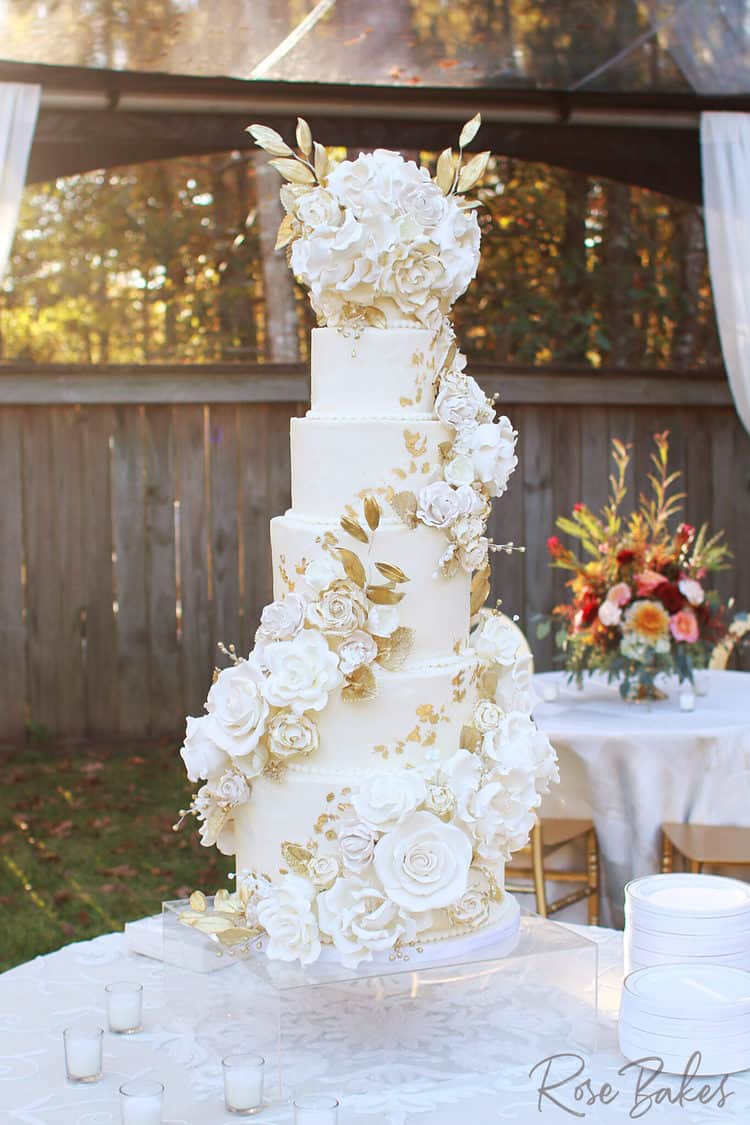 luxury wedding cake with cascading sugar flowers and edible gold highlights