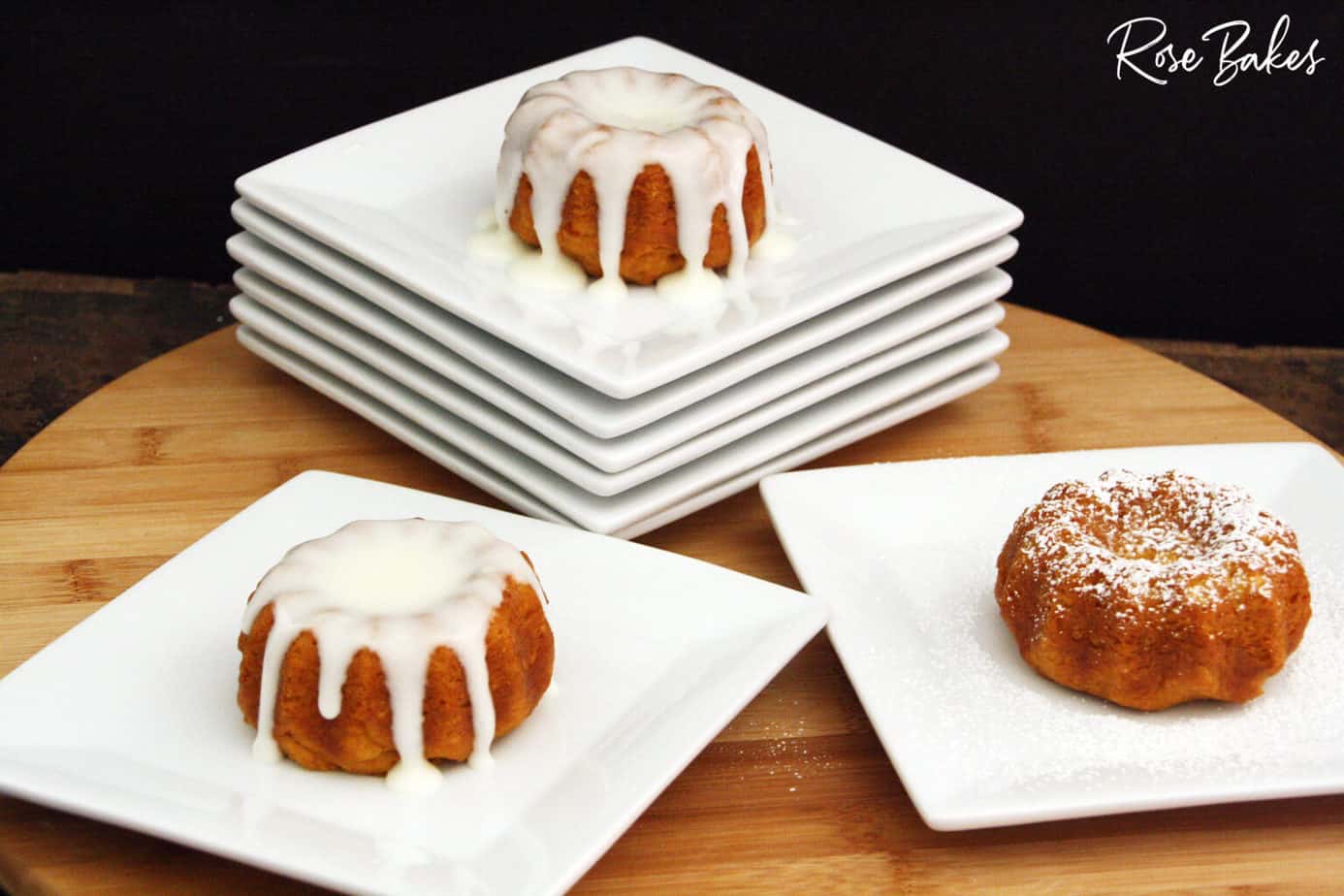 3 different mini pumpkin spice bundt cakes with cream cheese glaze on white plates.