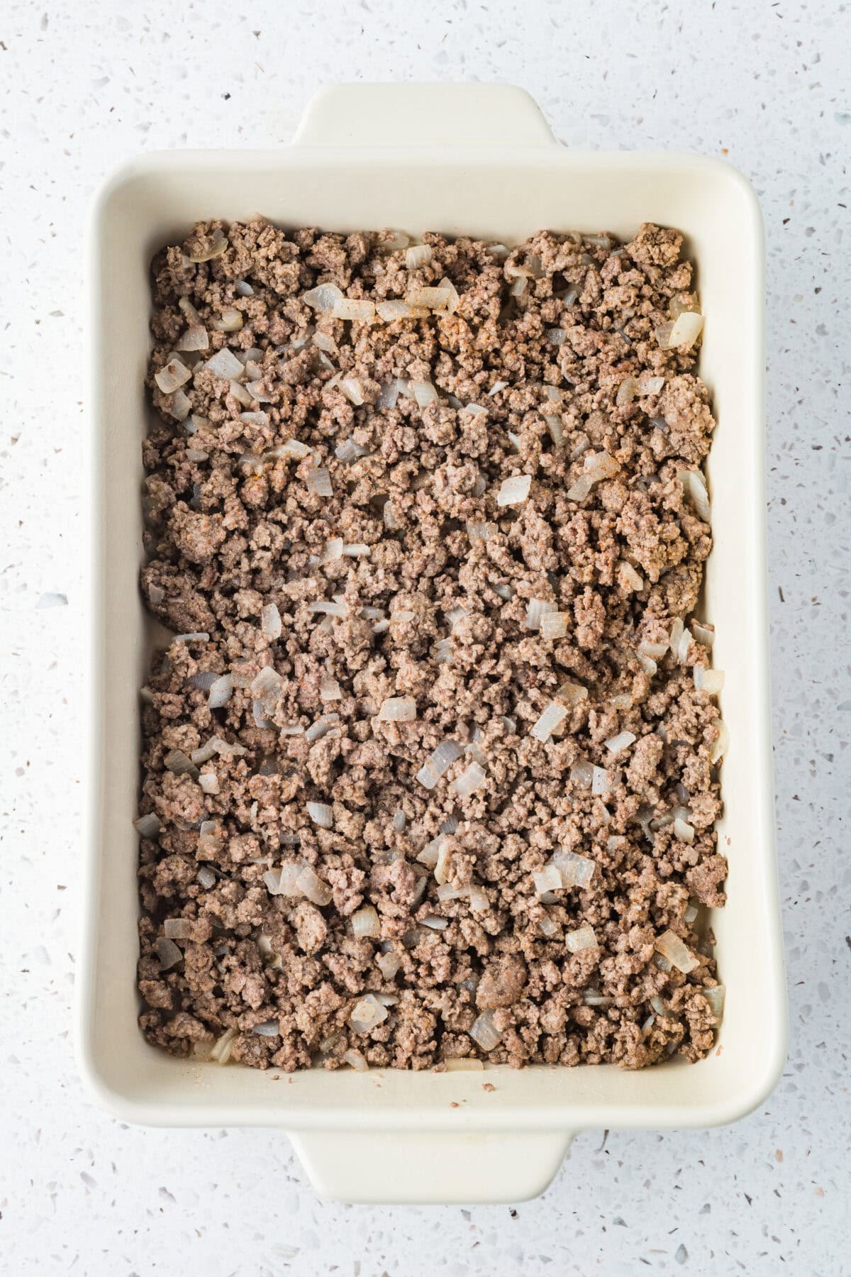 cooked ground beef and onions in a 9x13 baking dish