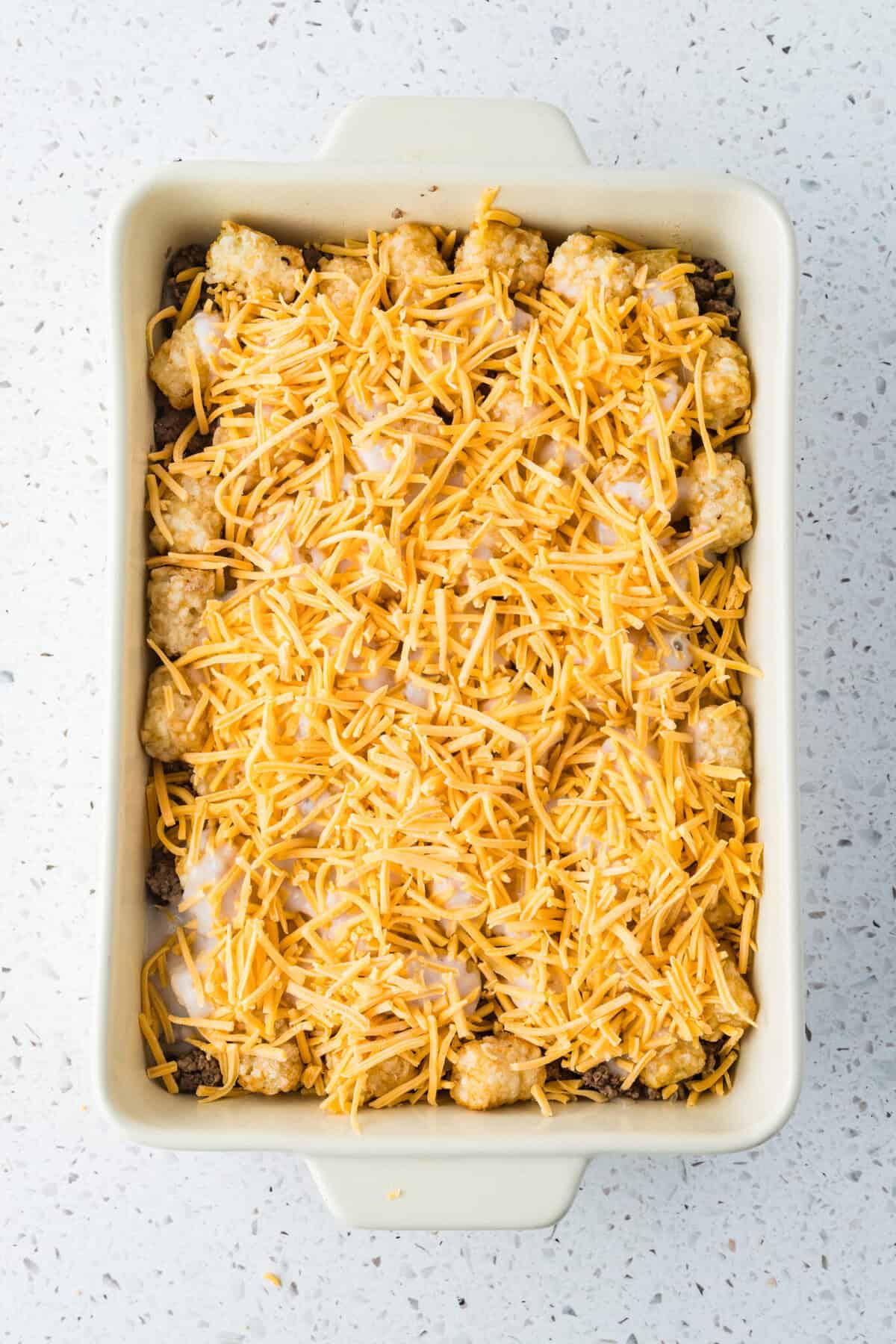 tater tot casserole process 06 shredded cheese on top of tater tot casserole