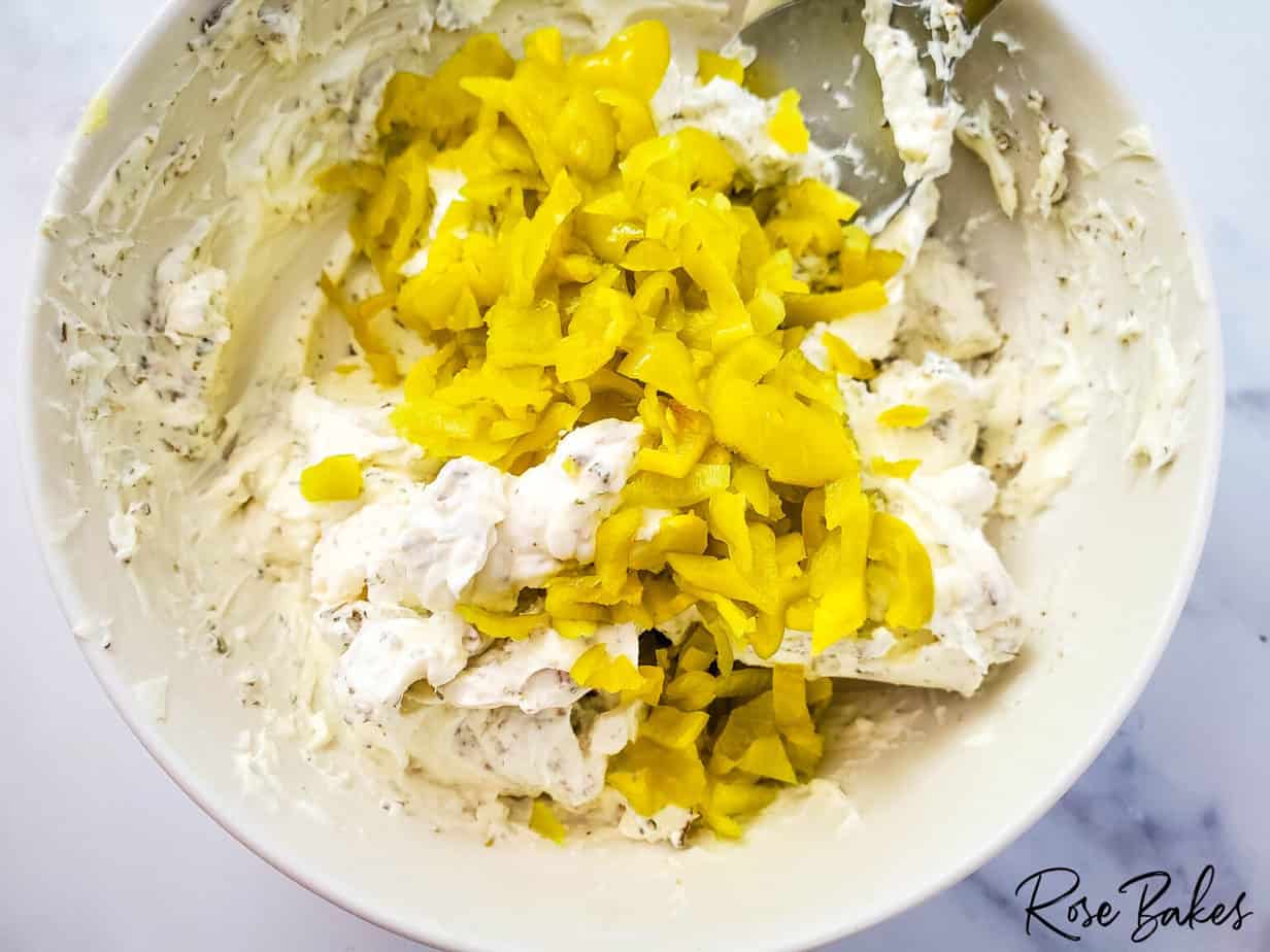 adding peppers to cream cheese mixture