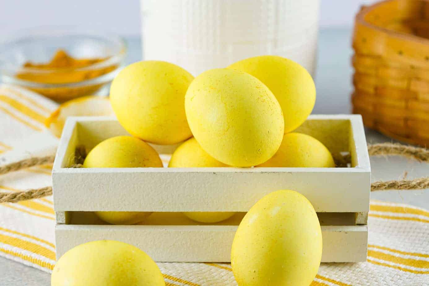 dyed easter eggs displayed in wooden crate on table